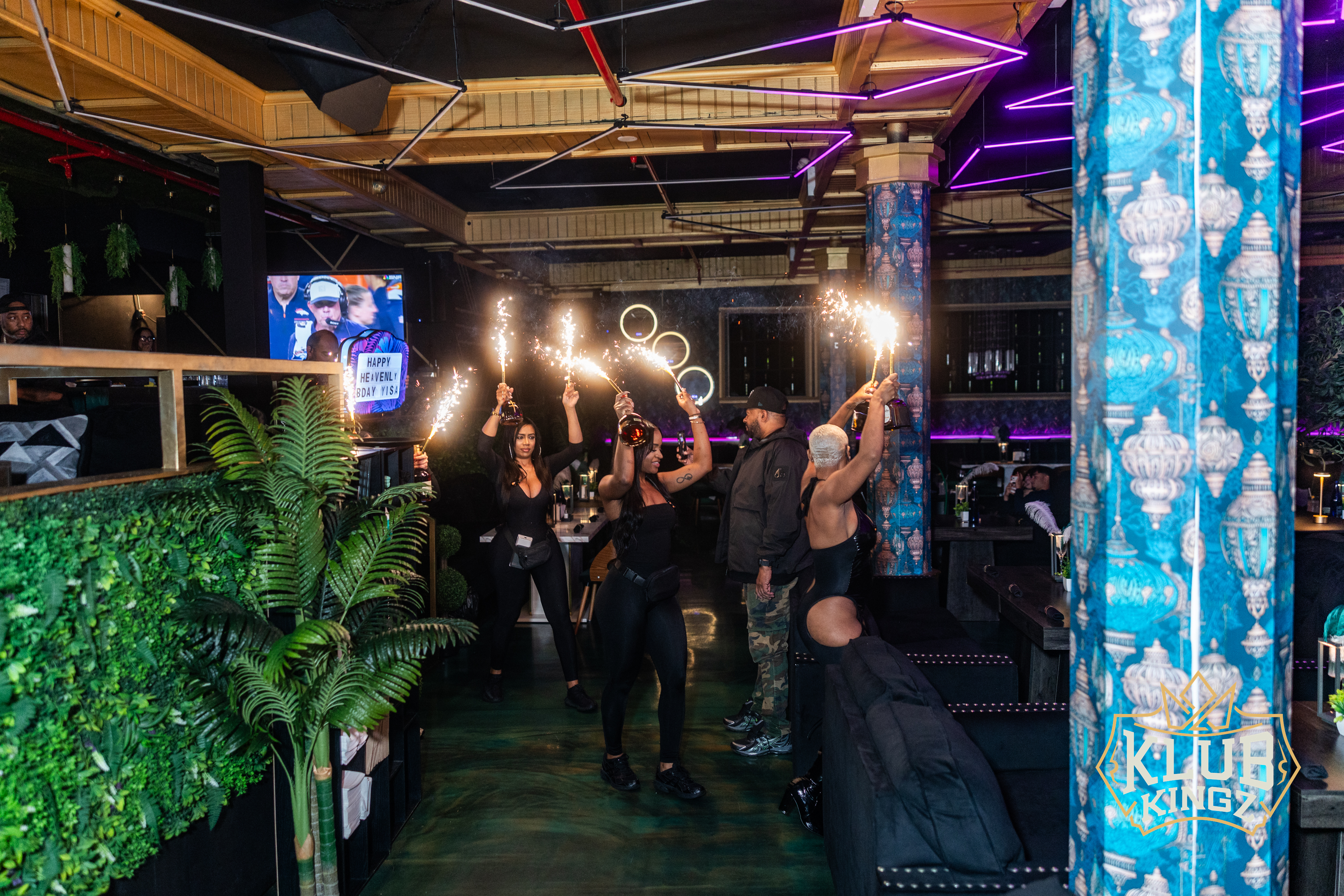 Bottle service staff carrying sparklers through Klub Kingz nightclub during a birthday celebration