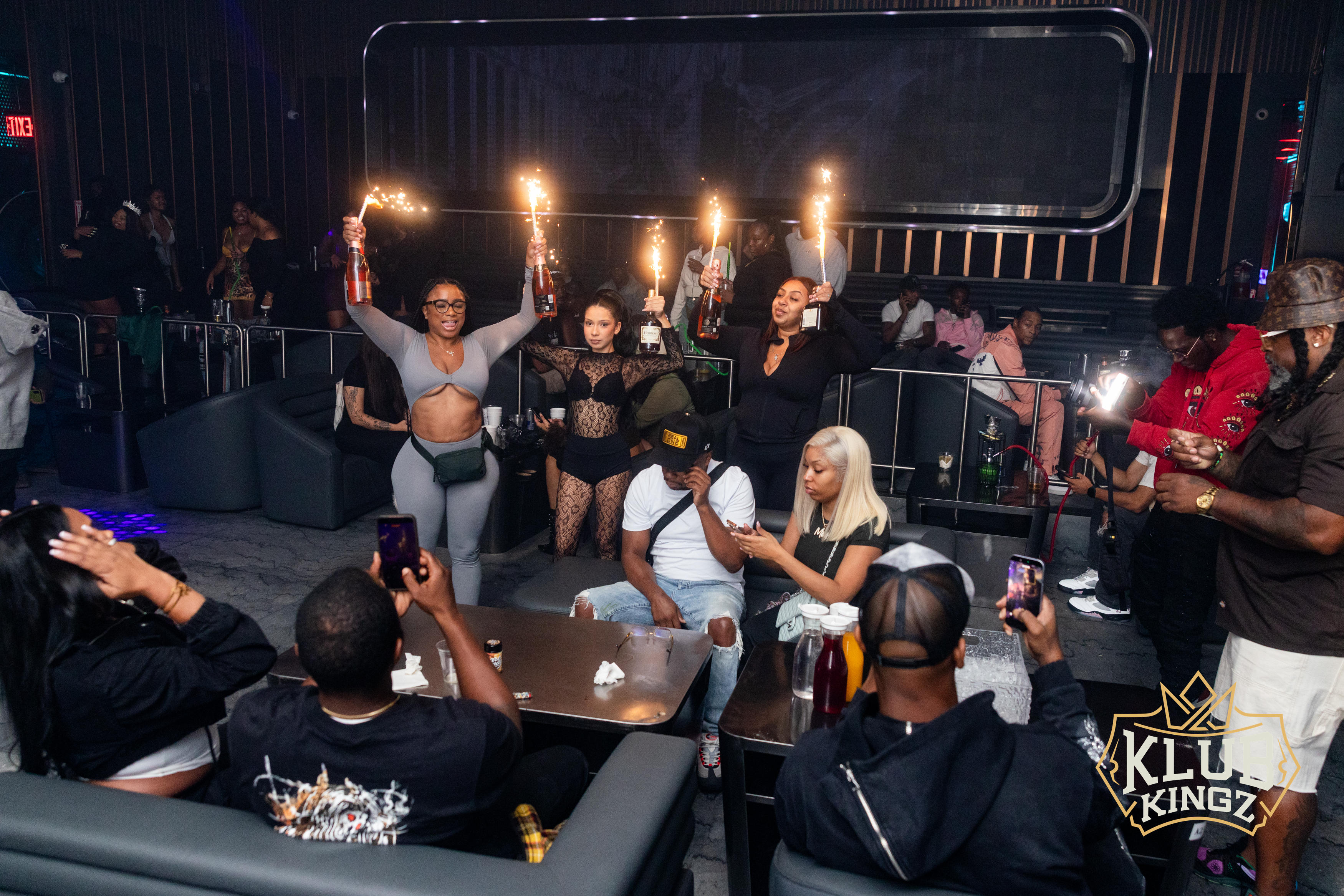 Guests raise sparkler-topped champagne bottles during a VIP bottle service celebration at Klub Kingz nightclub.