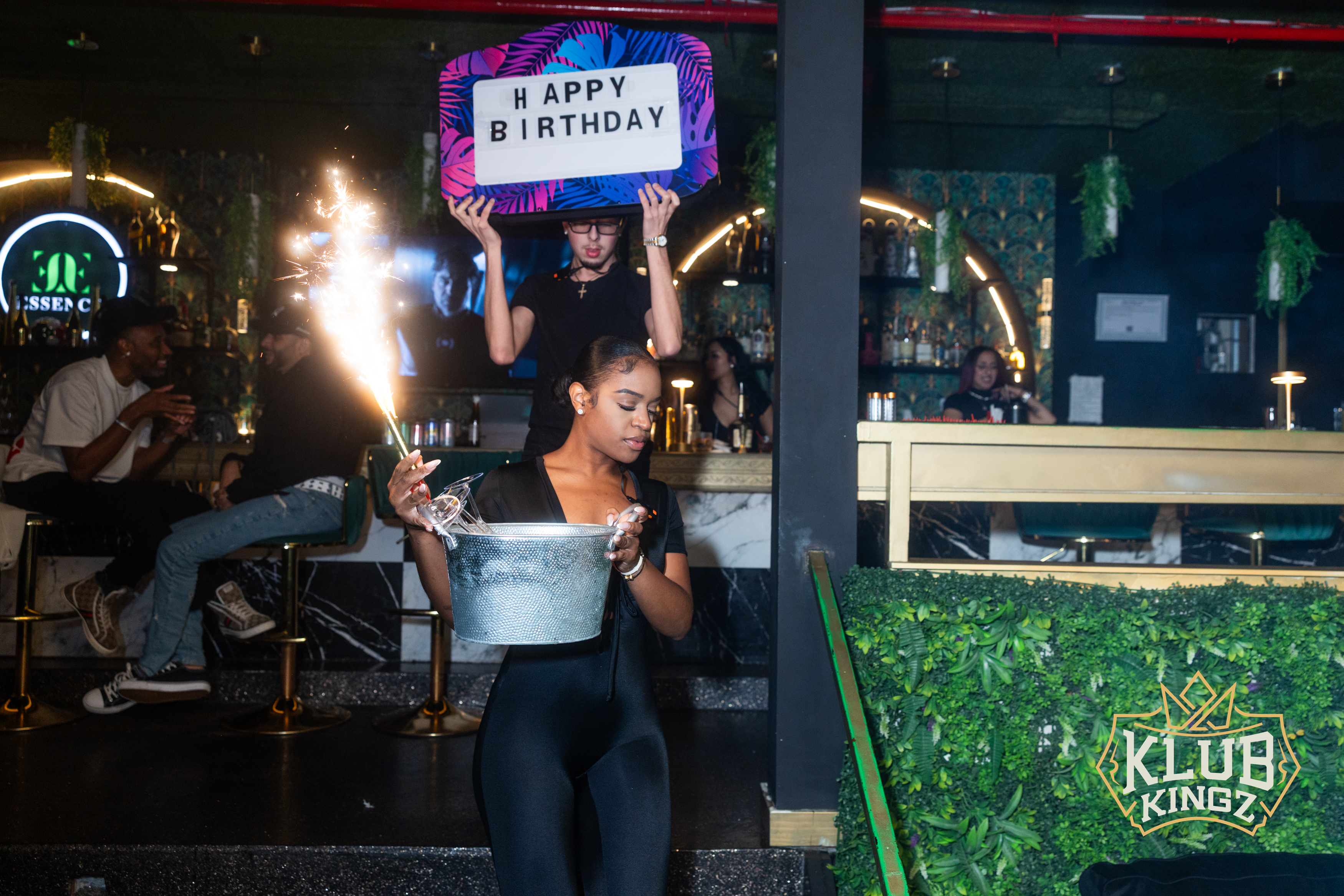Server delivers sparkler bottle service with Happy Birthday sign at Klub Kingz nightclub