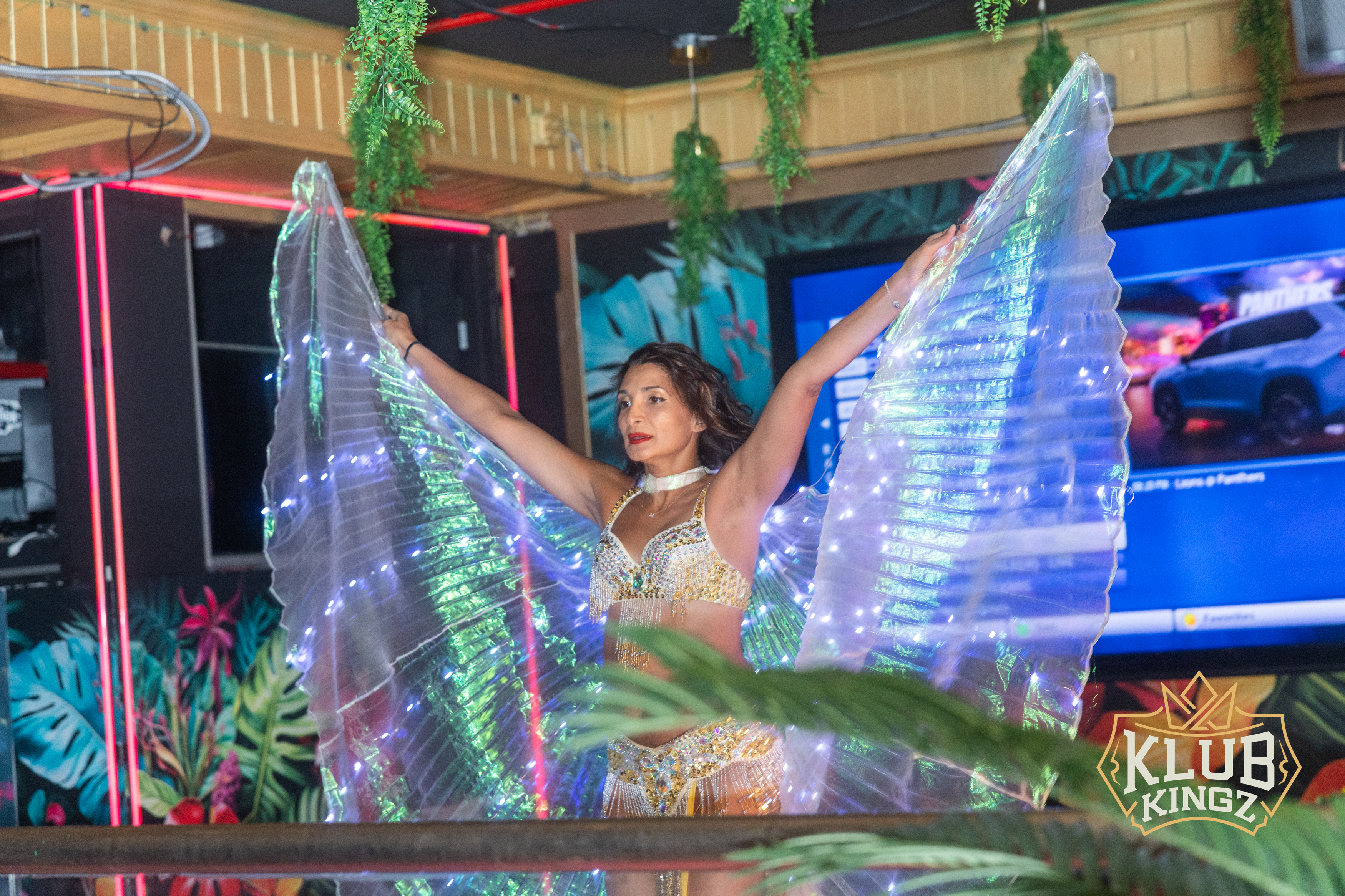Belly dancer performs with glowing LED isis wings during a live show at Klub Kingz