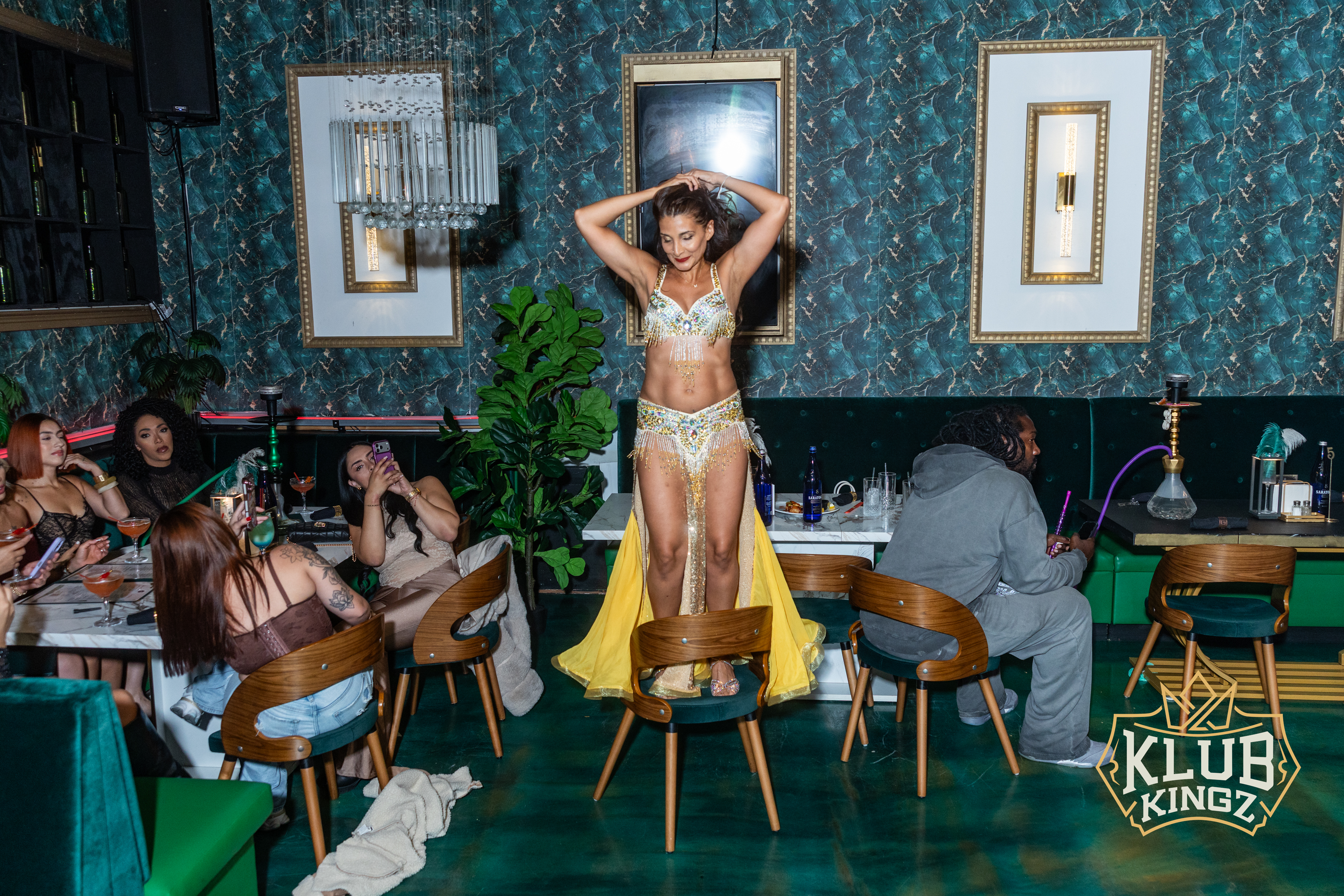 Belly dancer performing on a chair for guests at Klub Kingz lounge nightlife event