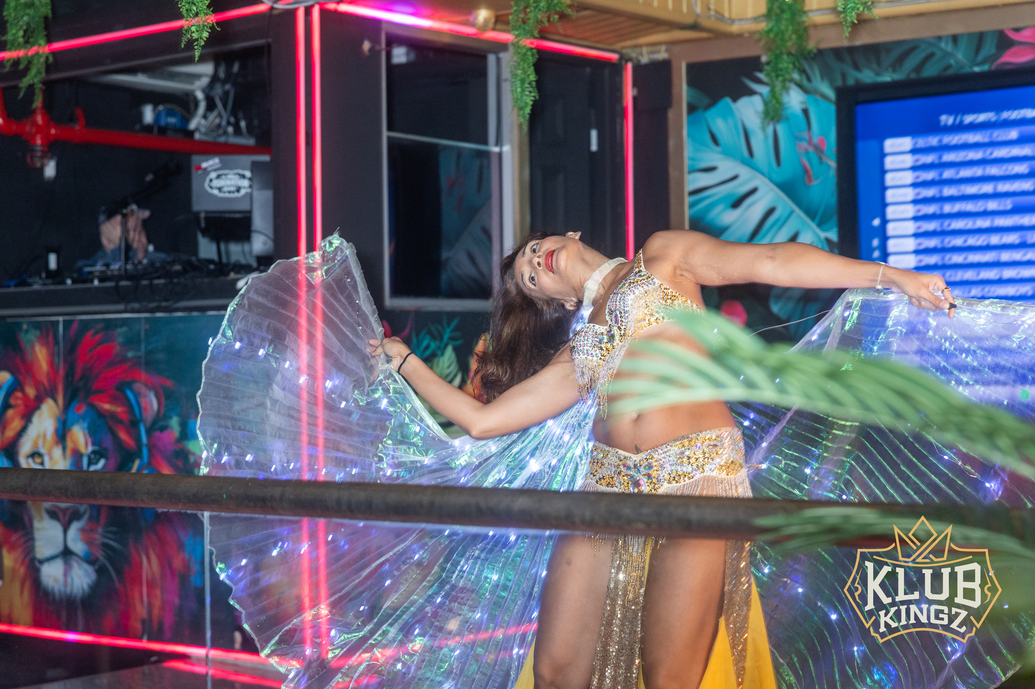 Dancer in sparkling gold costume with LED wings performing at Klub Kingz nightclub