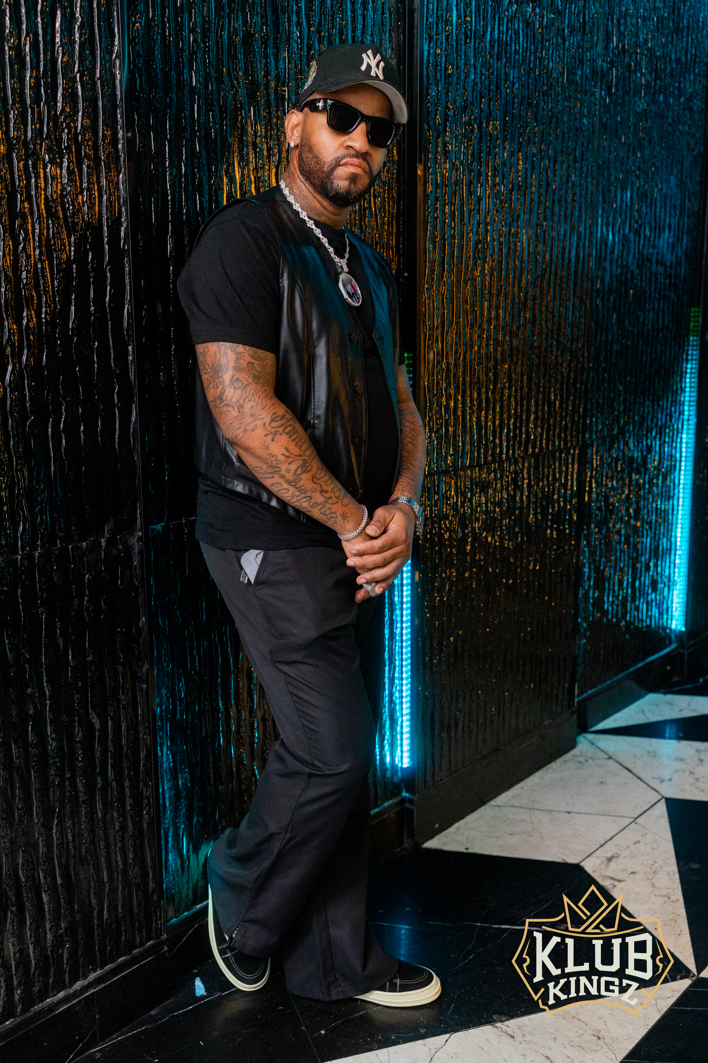 Stylish guest in black outfit and sunglasses posing at Klub Kingz nightclub entrance
