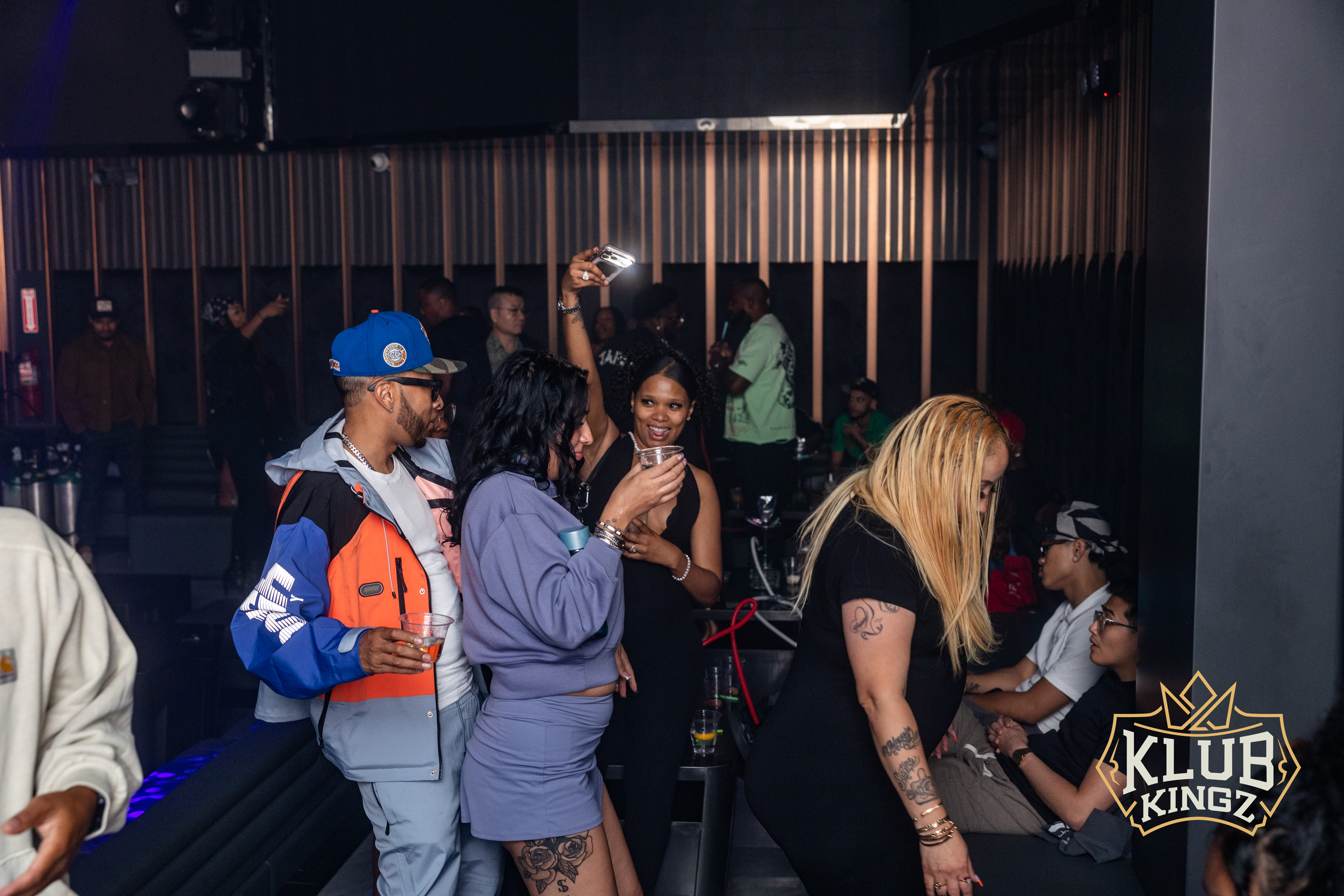 Guests mingling and taking photos with drinks on the dance floor at Klub Kingz nightclub