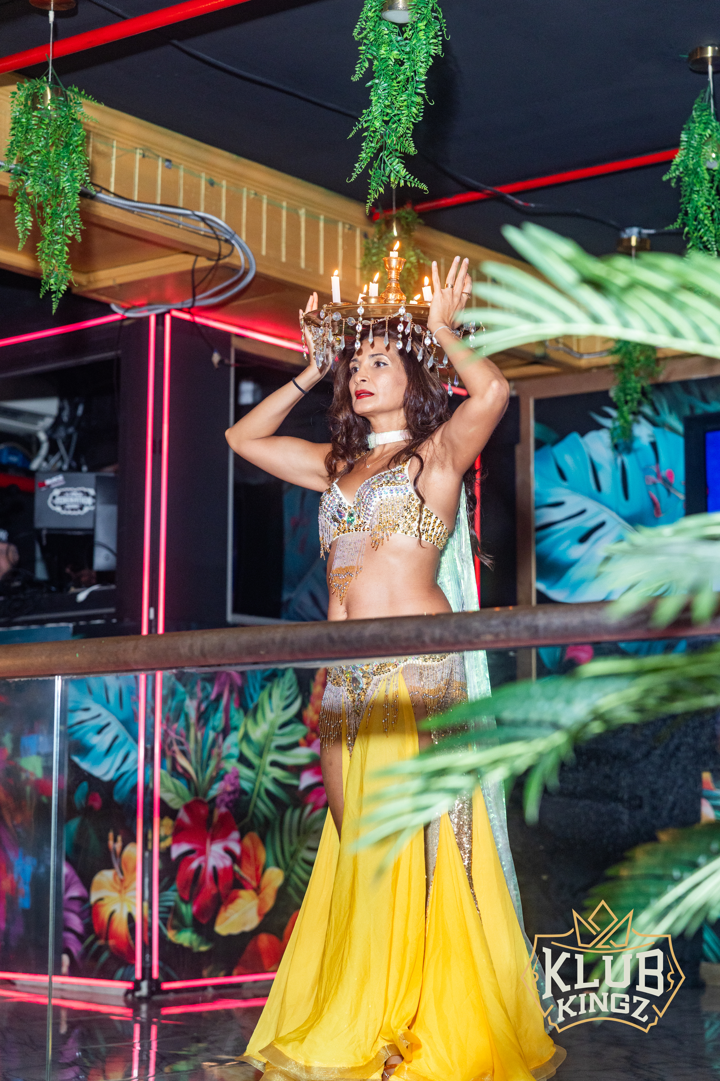 Belly dancer balancing lit candle tray on head during performance at Klub Kingz nightclub