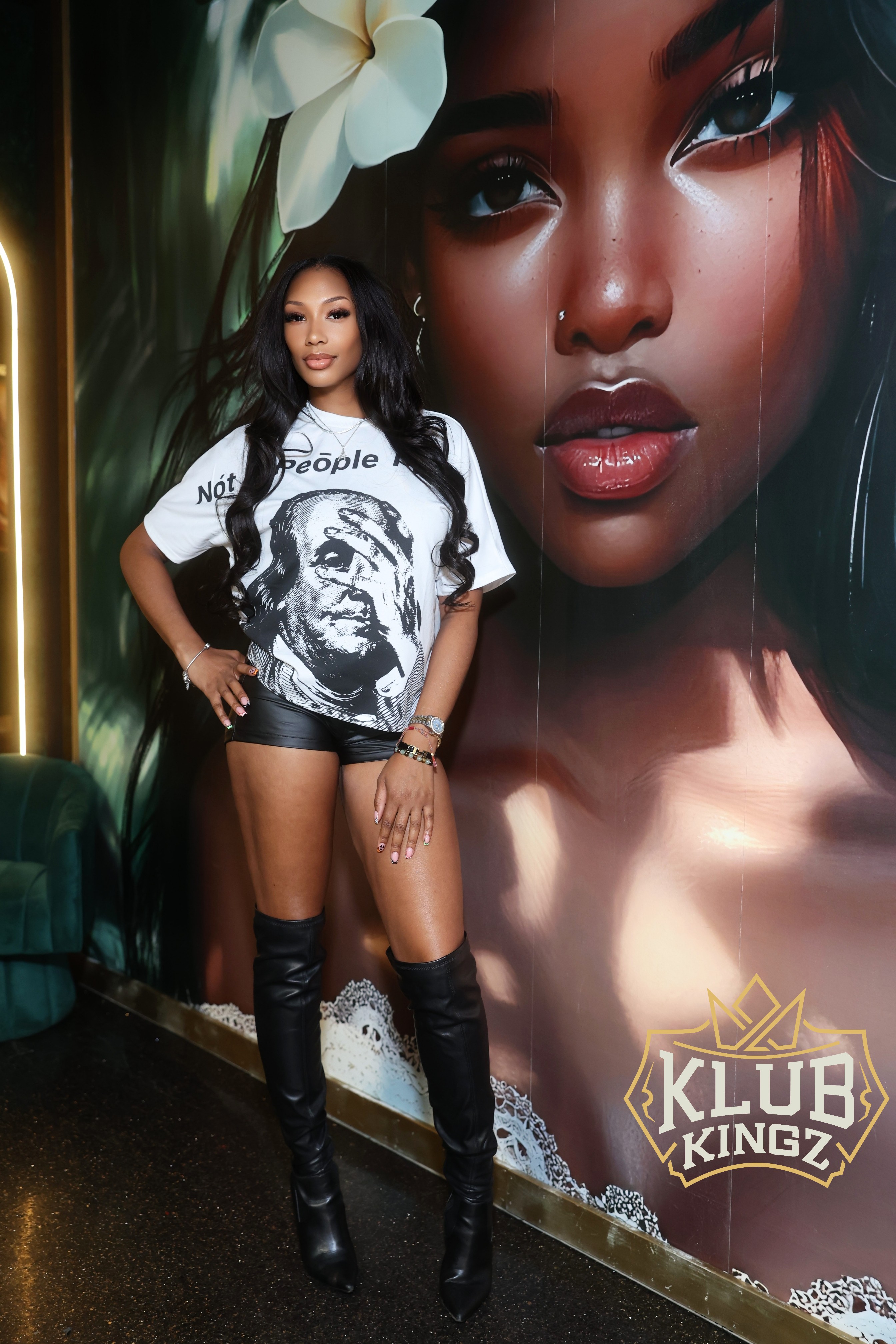 Woman posing in thigh-high boots at Klub Kingz nightclub mural wall