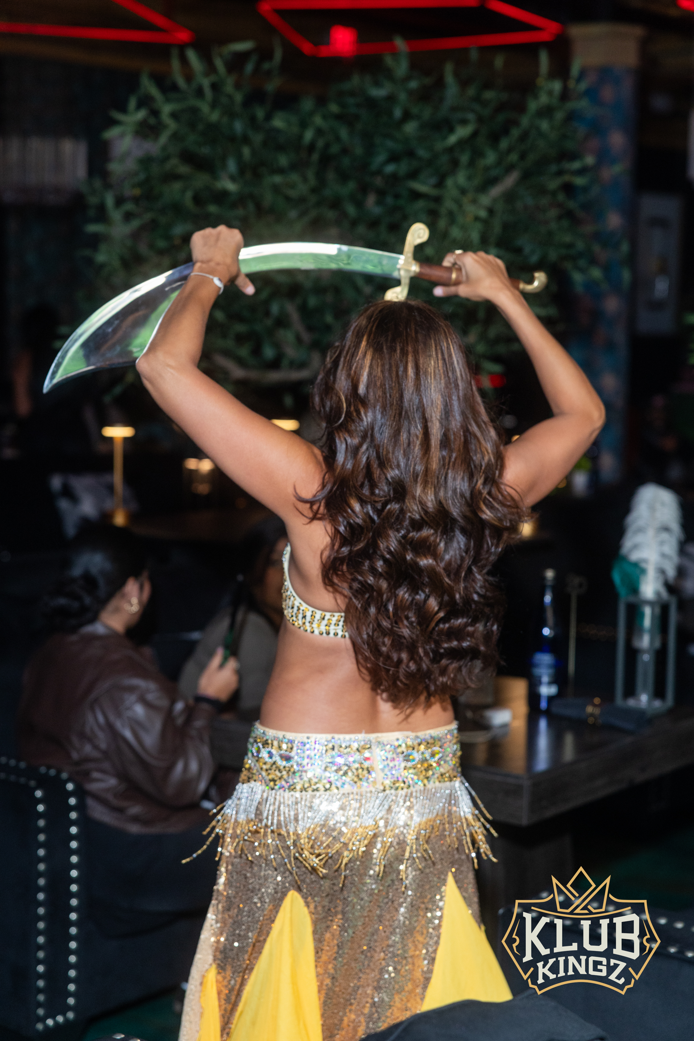 Belly dancer performing a sword dance in sequined costume at Klub Kingz nightclub